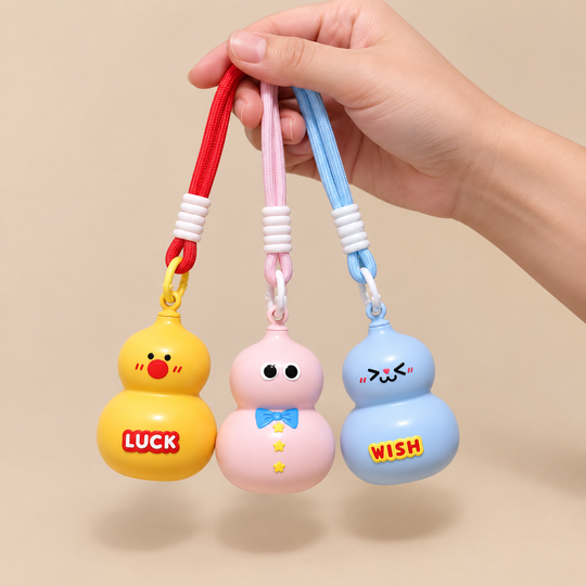 Hand-scale view of three Cute Gourd Mini Storage Keychains
